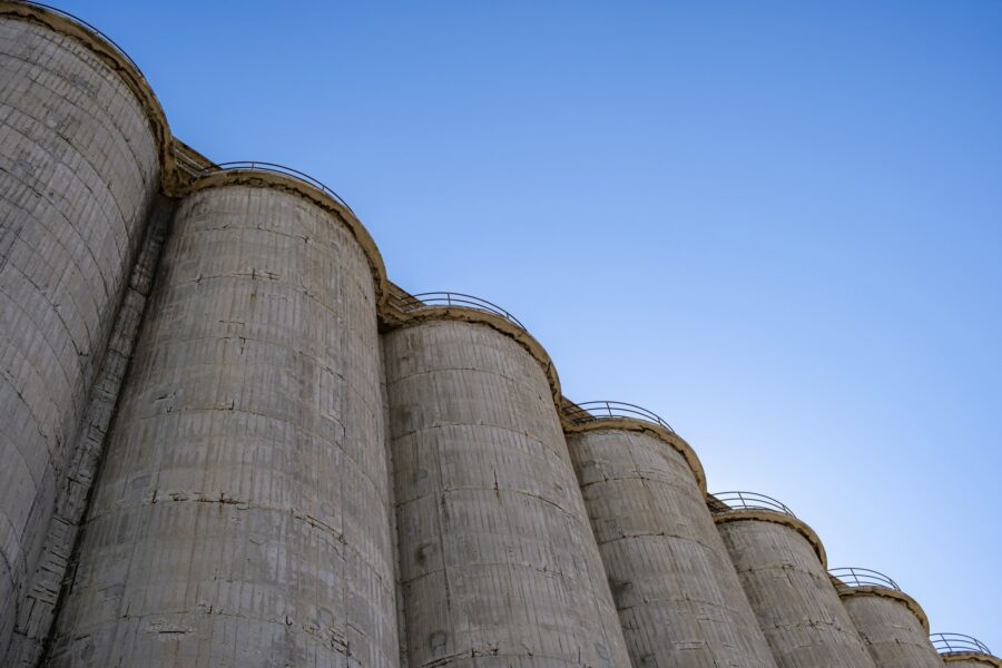 Large concrete industrial silos against blue sky background